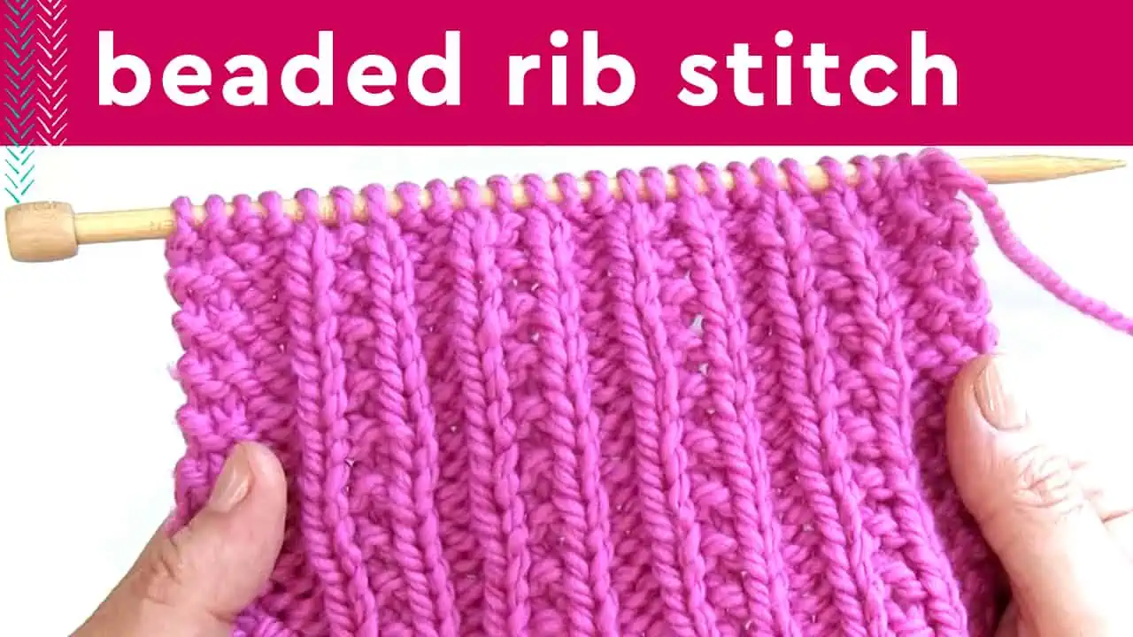 Beaded Rib Stitch textured knitting swatch in pink yarn on wooden needle.