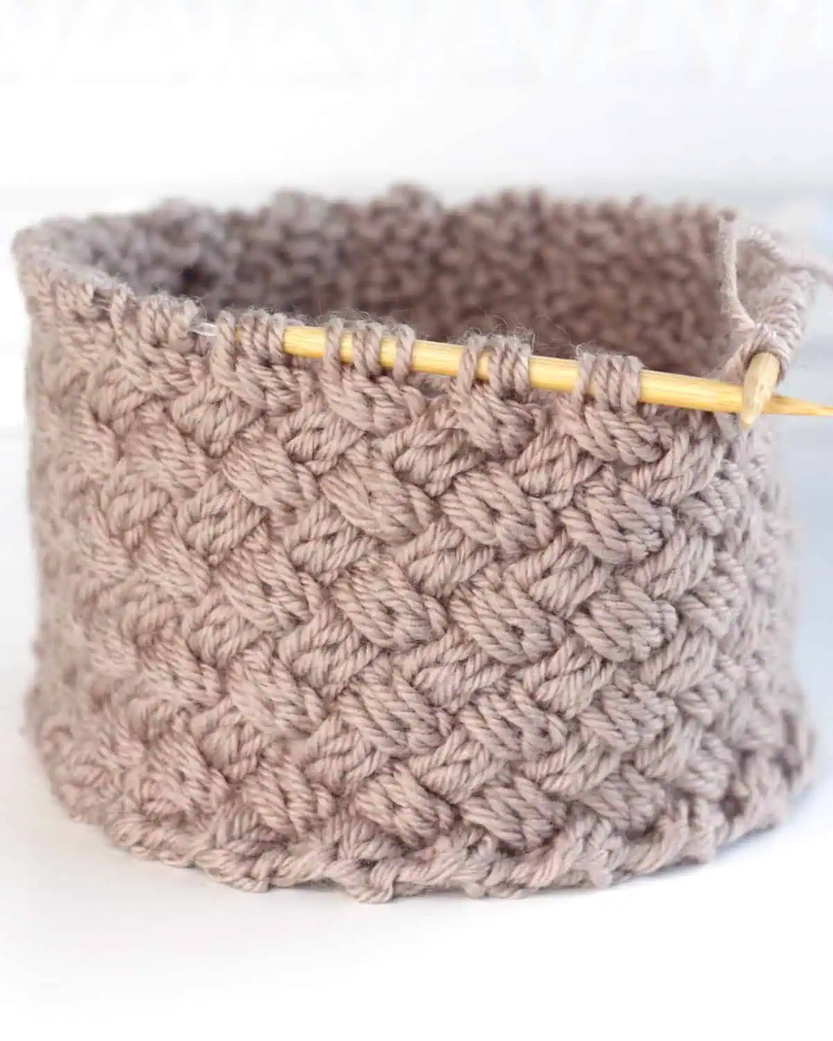 Diagonal Basket Weave Cable Stitch in gray-colored yarn on circular needles.
