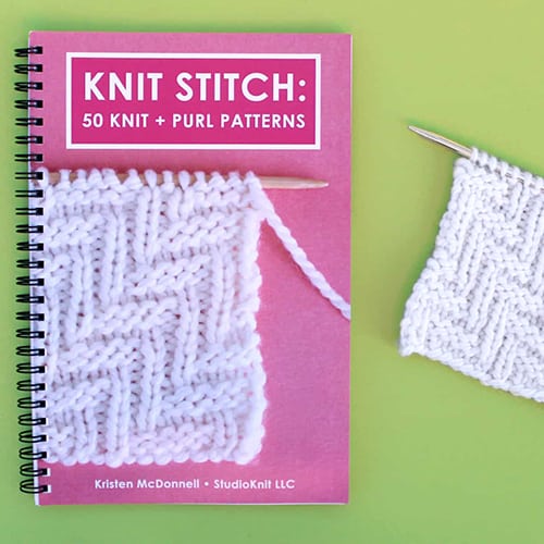 Knit Stitch Pattern Book with Lay Flat Wire-O Binding and Knitted Swatch on Green Background.
