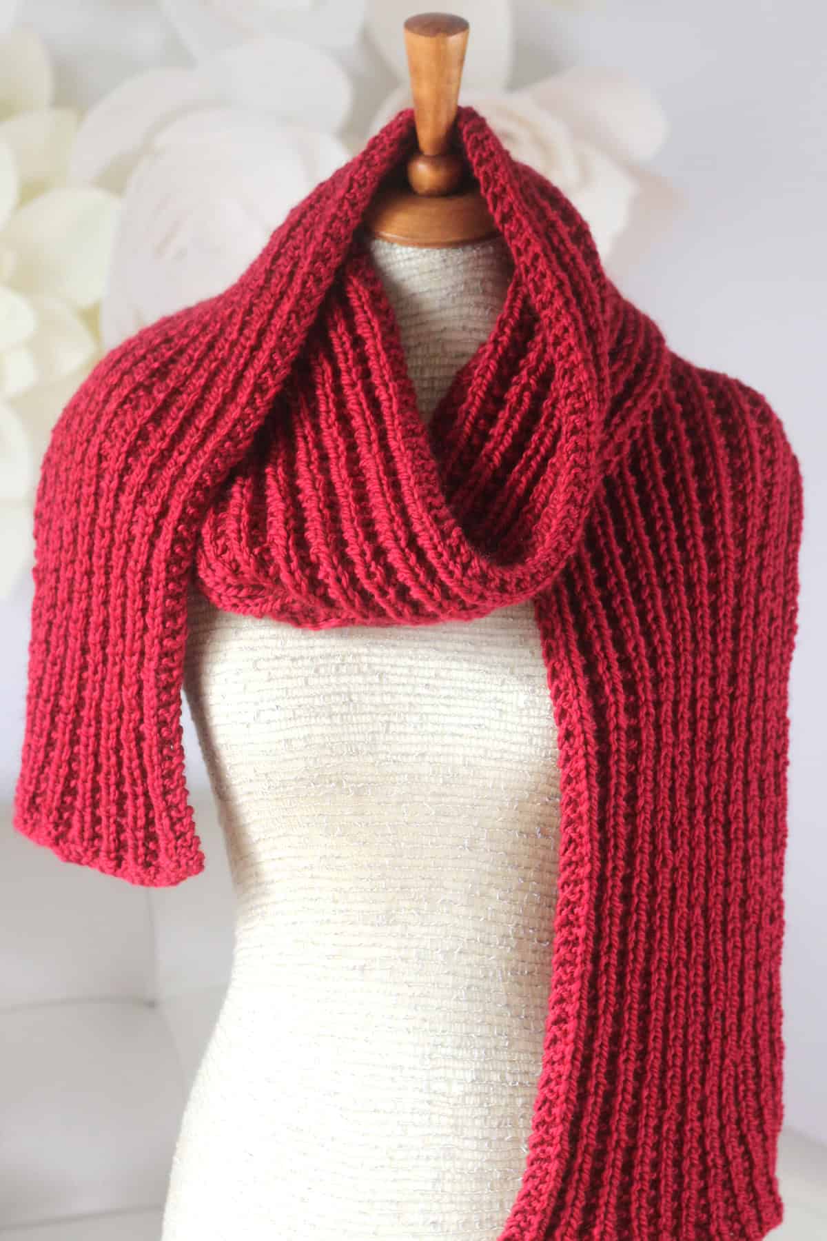Hot Frosty Scarf designed with Seeded Rib Stitch knitted in red colored yarn on mannequin.