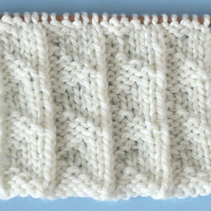 A close up of a white Pennant Pleating knitted stitch.