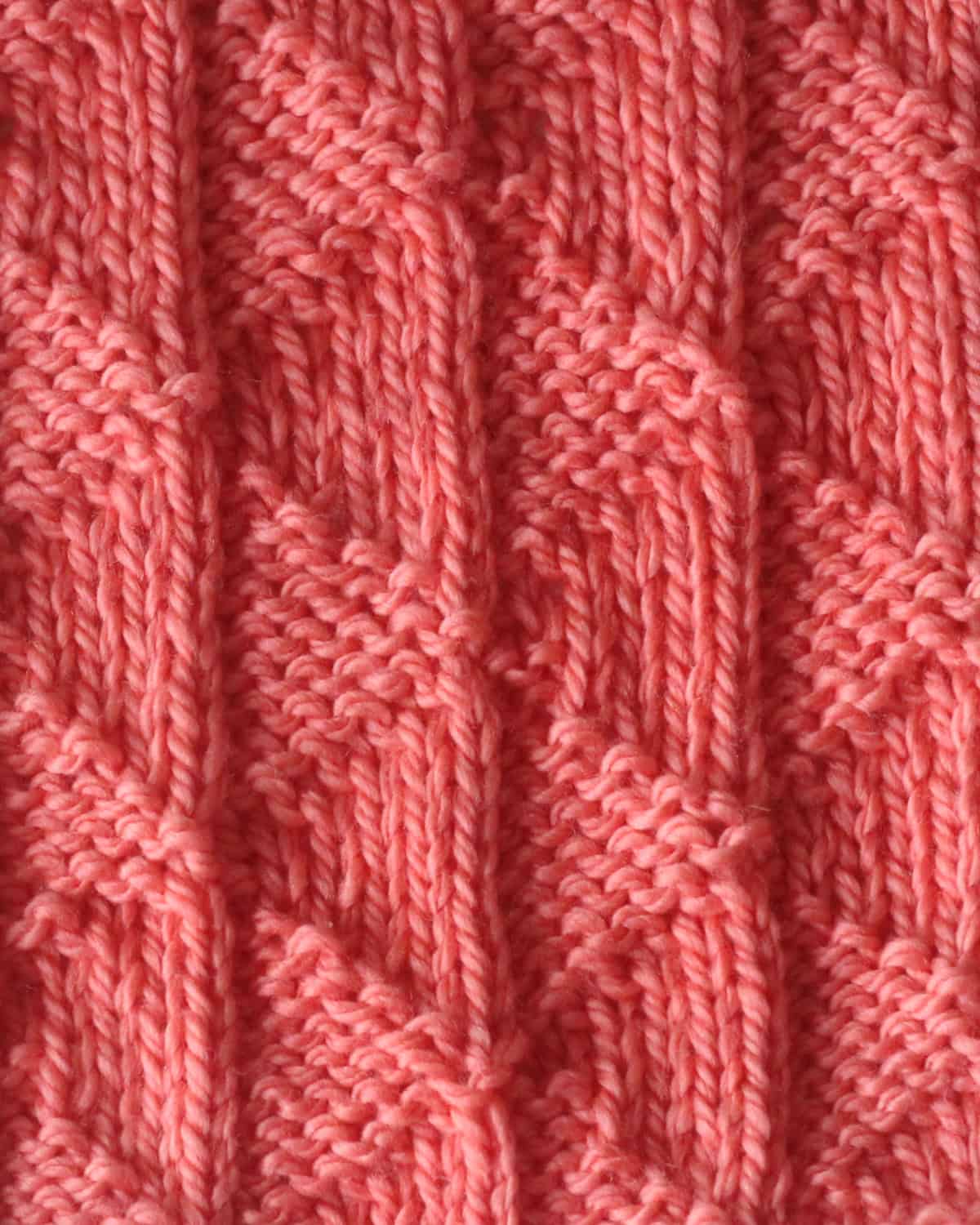Twin Sails knit stitch pattern in orange colored yarn.