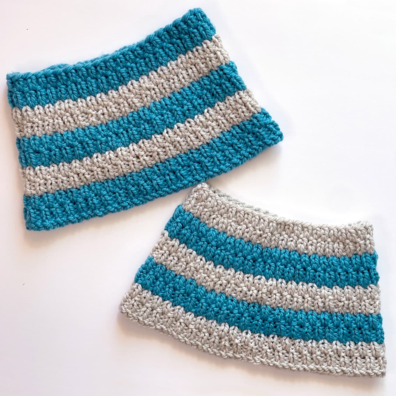 Two knitted cowls in alternating color stripes in the long raindrops texture.