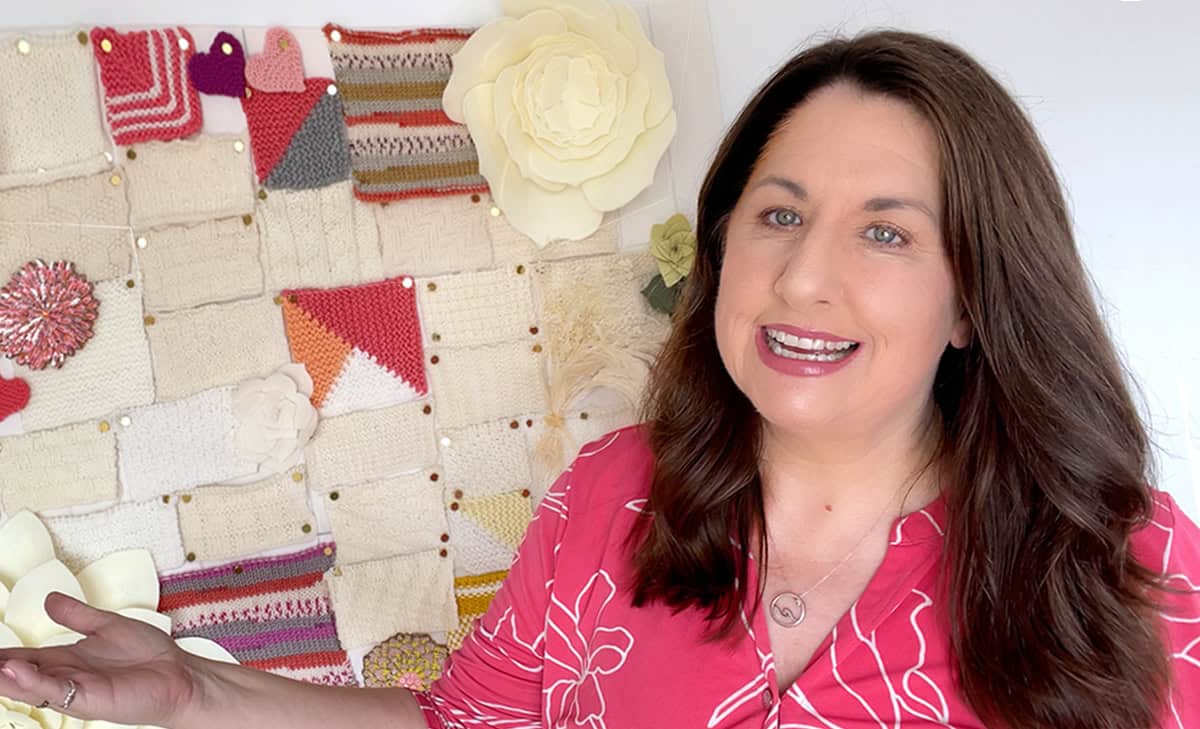 Kristen McDonnell in her Studio Knit knitting studio with stitch pattern swatches.