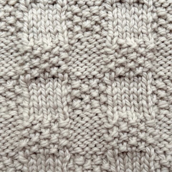 Close-up of Checkerboard Triple Weave Stitch swatch in ivory wool, showing smooth and bumpy checkerboard blocks.