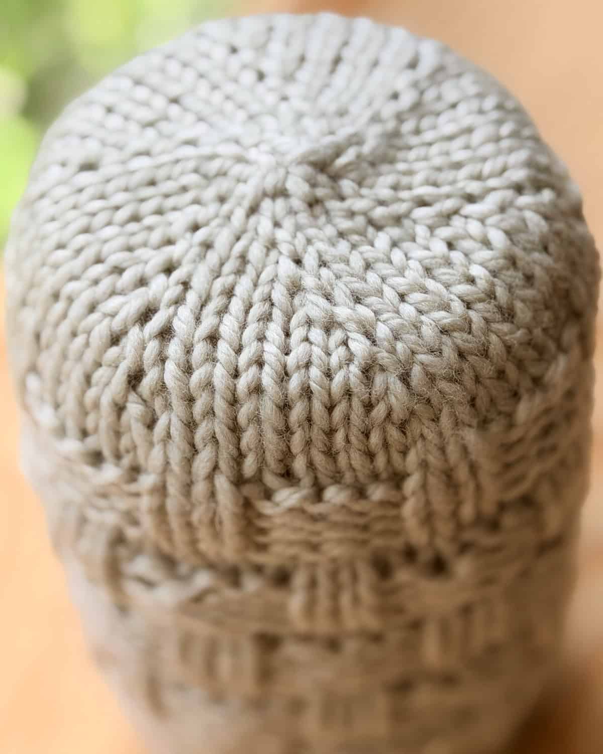 Bottom view of a knitted Basketweave Mason Jar Cozy showing circular base construction.
